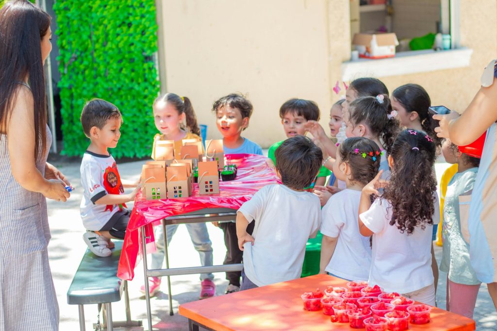 a group of children standing around a table